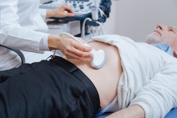 Älterer Mann bekommt eine Ultraschalluntersuchung am Bauch